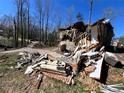 Exterior view of a severely damaged home with exposed walls and debris, indicating significant structural failure at 3440 Corral Dr, Marietta, GA 30066