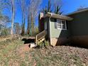 Green house exterior with brick foundation and siding, showing a back entrance and chimney in a grassy yard at 3440 Corral Dr, Marietta, GA 30066