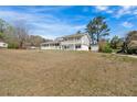 Exterior side view of the white home with a large yard and a quaint storage shed at 3679 Mill Glen Dr, Douglasville, GA 30135