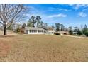 Expansive front lawn view showcasing the white home, adjacent house, and tree-lined street at 3679 Mill Glen Dr, Douglasville, GA 30135