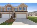 Beautiful brick two-story townhouse featuring a two-car garage and a well-manicured front yard at 935 Elwood St, Dacula, GA 30019