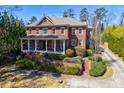 Beautiful brick two-story home with a covered porch and lush, mature landscaping at 1364 Manget Way, Dunwoody, GA 30338