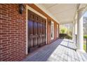 Inviting covered porch with brick facade, wood deck, and traditional columns at 1364 Manget Way, Dunwoody, GA 30338