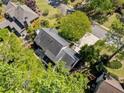Aerial view of the backyard with mature trees, a patio, and the home's dark roof at 745 Princeton Mill Run, Marietta, GA 30068