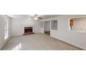 Spacious living room featuring a brick fireplace, ceiling fan and an opening to the kitchen at 921 Dunagan Way, Lawrenceville, GA 30045