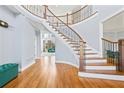 Elegant foyer featuring a curved staircase with hardwood floors and an open view to the living area at 100 Annes Ln, Sharpsburg, GA 30277