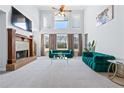Bright living room with high ceilings, a fireplace, large windows, and stylish green velvet sofas at 100 Annes Ln, Sharpsburg, GA 30277