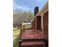 View of a brick patio with wooden rails, part of a red brick home with a chimney at 3153 Lake Monroe Rd, Douglasville, GA 30135