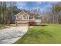 Two-story home with a lawn and attached garage, set on a lot with many trees surrounding the property at 440 Cottonpatch Rd, Lawrenceville, GA 30046