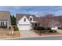 Exterior view of a white, two-story home with a blooming tree and a driveway at 1555 Diplomat Dr, Cumming, GA 30041