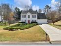 Charming two-story home with a well-manicured lawn and a spacious driveway leading to the garage at 6455 N Glen Dr, Cumming, GA 30028
