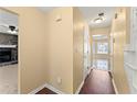 Hallway view of a living room fireplace and a sun room with large windows at 7438 Chilton Ln, Riverdale, GA 30296