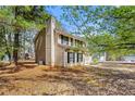 Tan two-story home featuring a well-maintained lawn and side yard at 7438 Chilton Ln, Riverdale, GA 30296