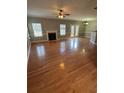 Spacious living room featuring gleaming hardwood floors, fireplace and large windows at 108 Creekwood Trl, Acworth, GA 30102