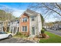 Inviting two-story townhome with brick and siding, complemented by lush landscaping and dedicated parking at 4645 Valais Ct # 135, Alpharetta, GA 30022
