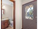 Inviting entryway next to a half bathroom with dark wooden cabinets with a decorative glass front door at 5595 Wylmoor, Norcross, GA 30093