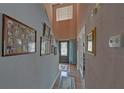 Hallway featuring a high ceiling, framed artwork, and a glimpse of the front door with decorative glass at 3000 Gallery Walk, Snellville, GA 30039
