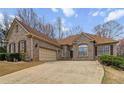 Attractive one-story brick home with a spacious driveway, showcasing its inviting curb appeal and convenient two-car garage at 3211 Blaisdell Rd, Buford, GA 30519