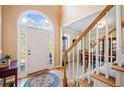Bright foyer with hardwood floors, staircase, and an arched window above the front door at 2285 Briarwood Trl, Cumming, GA 30041