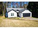 Charming single-story home featuring black trim, a gray roof, and a two-car garage at 3065 Wildflower Ln, Snellville, GA 30039