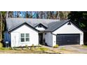 Charming single-story home featuring black trim, a gray roof, and a two-car garage at 3065 Wildflower Ln, Snellville, GA 30039