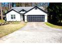 Charming single-story home featuring black trim, a gray roof, and a two-car garage at 3065 Wildflower Ln, Snellville, GA 30039
