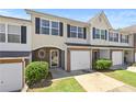 Inviting townhome featuring a one-car garage, brick accents, and a well-maintained lawn at 695 Georgetown Ct, Jonesboro, GA 30236