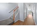 Inviting hallway showcasing hardwood floors, a staircase, and neutral paint at 695 Georgetown Ct, Jonesboro, GA 30236