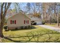 Exterior view of a charming home with a manicured lawn and mature trees showcasing classic curb appeal at 2073 Lou Ct, Grayson, GA 30017