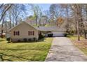 Ranch-style home featuring red shutters, attached garage, mature trees, and well-manicured lawn providing great curb appeal at 2073 Lou Ct, Grayson, GA 30017