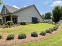 Well-maintained side yard with lush green grass, manicured hedges, and a charming porch at 310 Ellington Dr, Canton, GA 30115