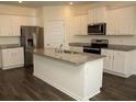 Modern kitchen featuring a center island, stainless steel appliances, and white cabinetry at 443 Faulkner St, Stockbridge, GA 30281