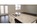 Kitchen island with granite countertop and stainless steel appliances overlooking living area at 443 Faulkner St, Stockbridge, GA 30281