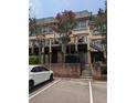 Townhome complex with brick facade, balconies, stairs, and parking, set amidst mature trees at 6980 Roswell Rd # E11, Atlanta, GA 30328