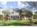 View of the home's backyard, showcasing a patio, lush lawn, and mature trees on a sunny day at 2996 Bea Mar Dr, Marietta, GA 30062