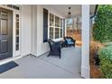 Inviting covered front porch with comfortable wicker seating and a view of the manicured front yard at 310 Persimmon Dr, Sharpsburg, GA 30277