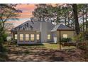 Exterior view of home featuring a swing and large backyard surrounded by trees at 3100 Plantation Run Dr, Loganville, GA 30052