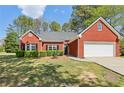 Charming brick home with a well-manicured lawn and mature landscaping at 3100 Plantation Run Dr, Loganville, GA 30052