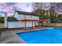 Charming home exterior with refreshing in-ground swimming pool and covered outdoor patio at 10540 Willow View Cir, Alpharetta, GA 30022
