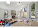 Sunlit living room with a stone fireplace, large windows, and a vaulted ceiling at 2724 Long Lake Ne Dr, Roswell, GA 30075