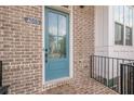 Close-up of a blue front door with glass panel, brick facade and black railing at 4565 Sims Park Overlook, Suwanee, GA 30024