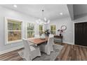 Well-lit dining room features modern chandelier, hardwood floors, and large windows for a bright and inviting atmosphere at 99 Brown Ave, Atlanta, GA 30315