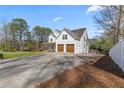 Side view of a charming two-story farmhouse with a spacious driveway and lush greenery at 111 Franklin Rd, Woodstock, GA 30188
