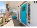 Inviting front porch with a turquoise door, hanging porch swing, and a 'welcome' mat at 111 Franklin Rd, Woodstock, GA 30188