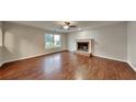 Bright living room featuring hardwood floors, a fireplace, and a large window at 1809 Fairpointe Trce, Stone Mountain, GA 30088