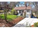 Wide shot of a charming brick home with a well-maintained lawn, long driveway, and mature trees at 2795 Kimmeridge Dr, Atlanta, GA 30344