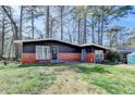 Charming single-Gathering house with mature trees, a brick foundation and lush green lawn at 3007 Pasadena Dr, Decatur, GA 30032