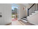 Bright foyer with wood floors, staircase with black iron railing, and view of front yard at 3061 Stone Bridge Sw Trl, Conyers, GA 30094