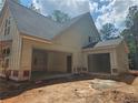 New home's exterior featuring a three car garage under a sleek, modern roof line and light siding at 6841 Phillips Mill Rd, Douglasville, GA 30135