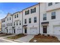 Exterior view of modern townhomes showing garages, small yards, and multiple windows at 3135 Washburn St, Atlanta, GA 30354